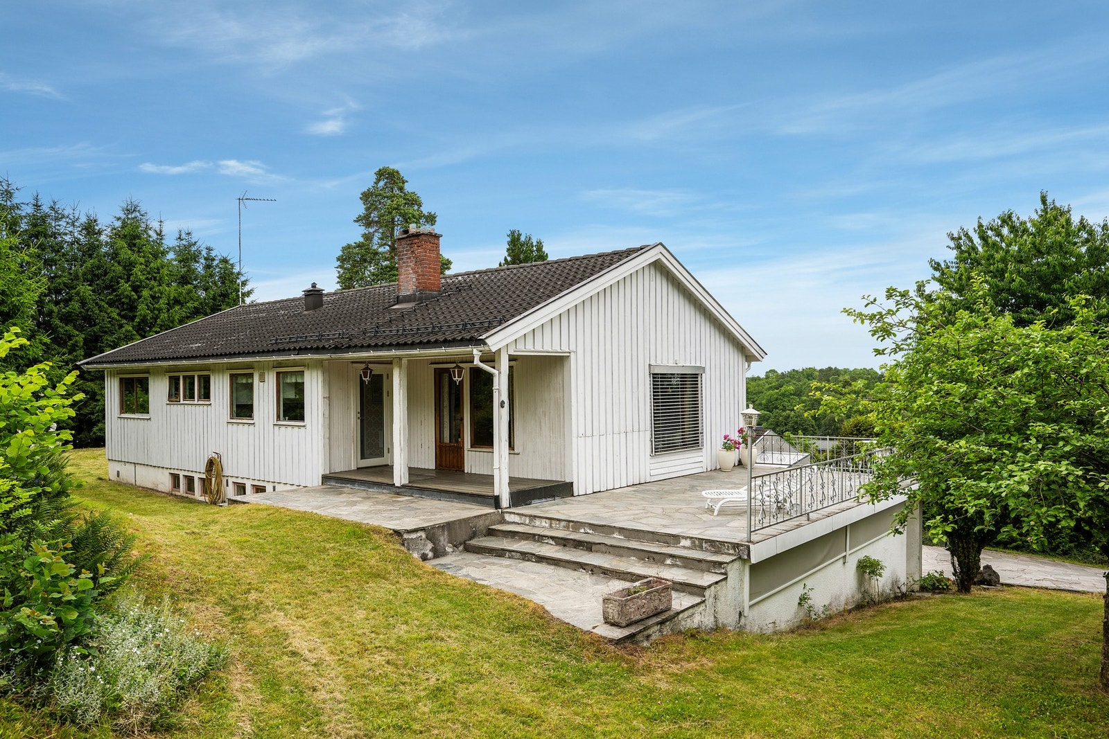 Her ser vi litt av bakhagen som både har plen, naturtomt og en stor terrasse både mot syd og vest Galleribilde