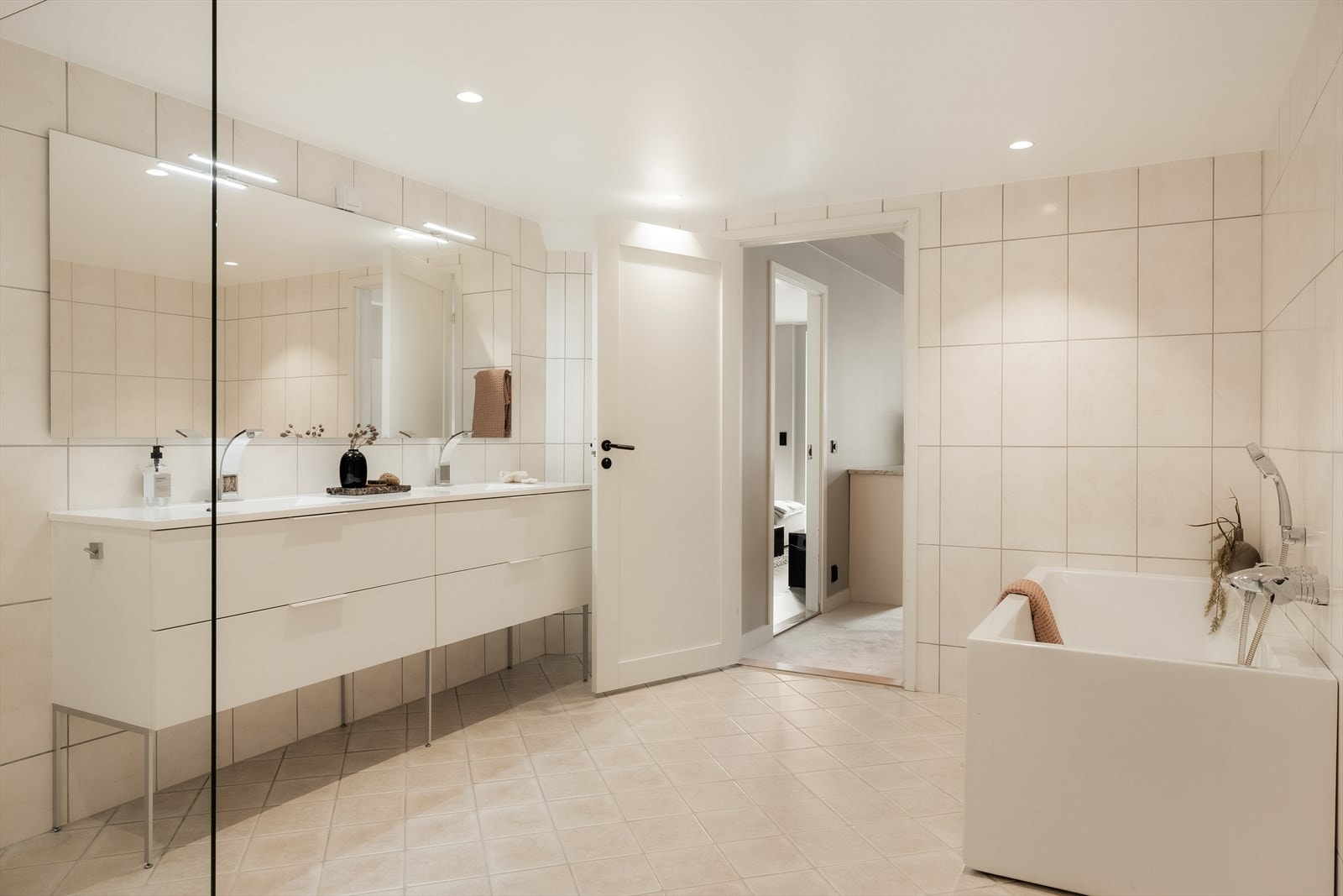 Badet er romslig og innredet med dobbel servant, vegghengt toalett, badekar og dusj Galleribilde