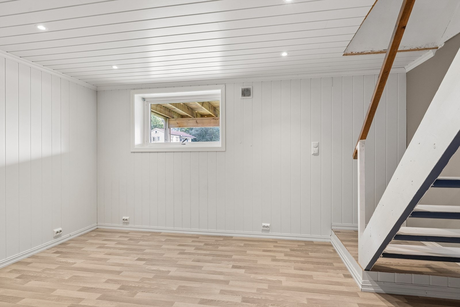 Et av soverommene i underetasjen, med trapp opp til hovedetasjen. Galleribilde