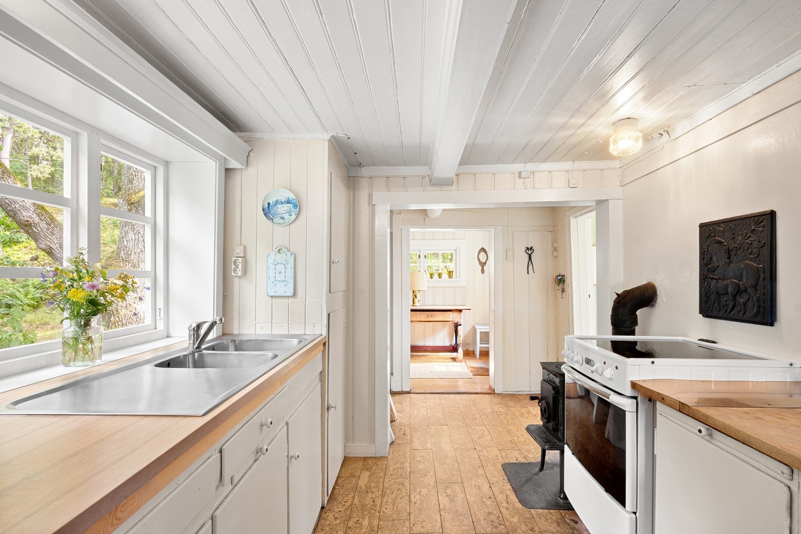 Kjøkkenet ligger i eget rom og har en enkel, funksjonell innredning med malte fronter og benkeplater i laminat og heltre. Galleribilde