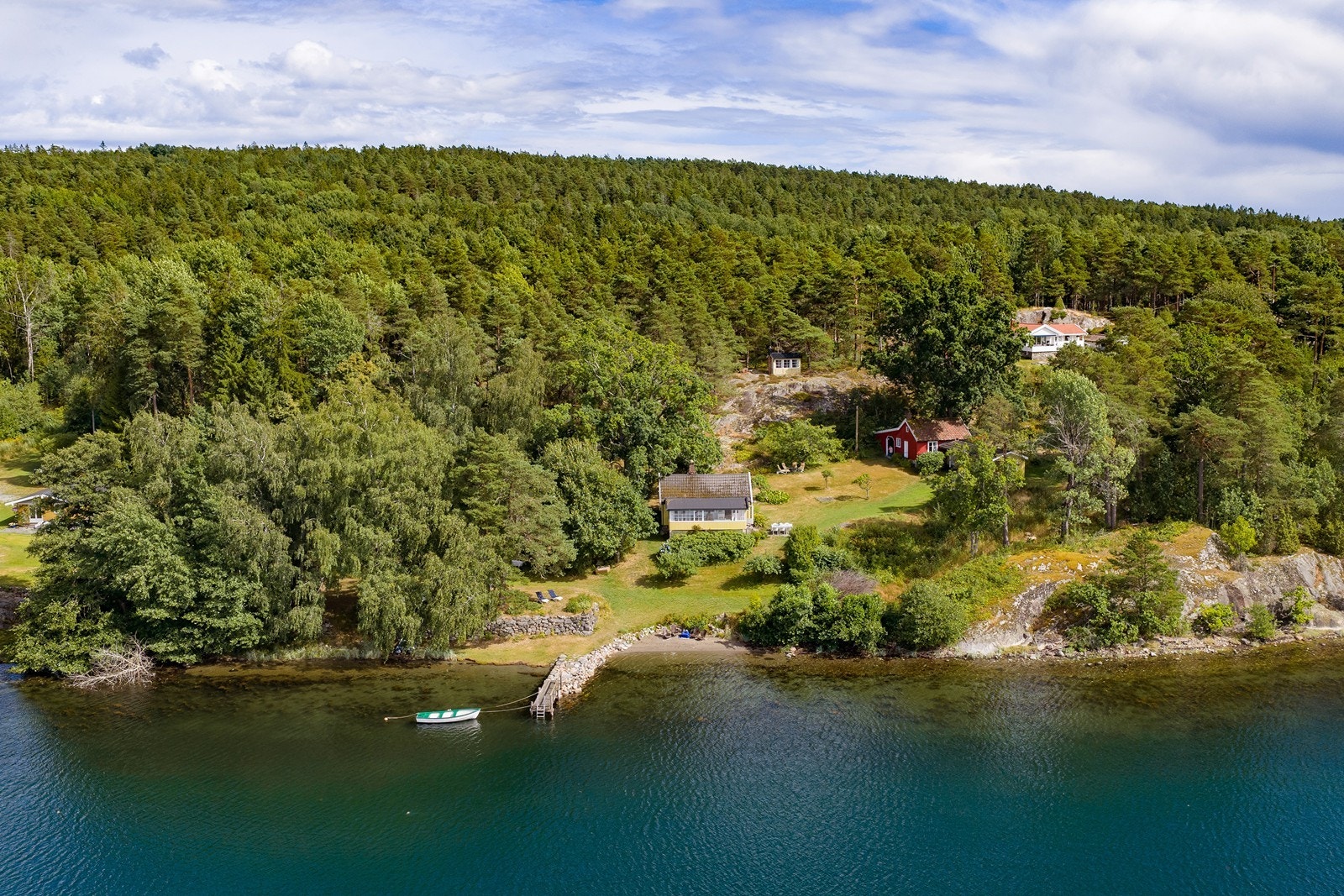 Her ligger eiendommen omgitt av fjorden, svaberg og frodig vegetasjon - en herlig grønn oase. Galleribilde