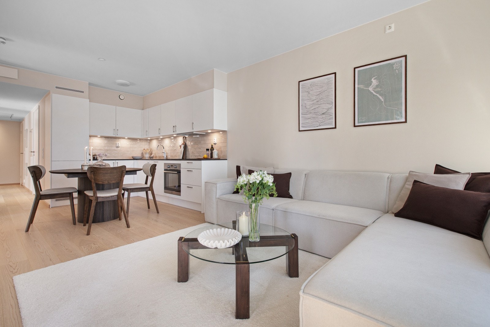 Den åpne kjøkken- og stueløsningen gir god plass til både spisebord og sofamøblement, og legger til rette for en sosial og luftig romfølelse. Galleribilde
