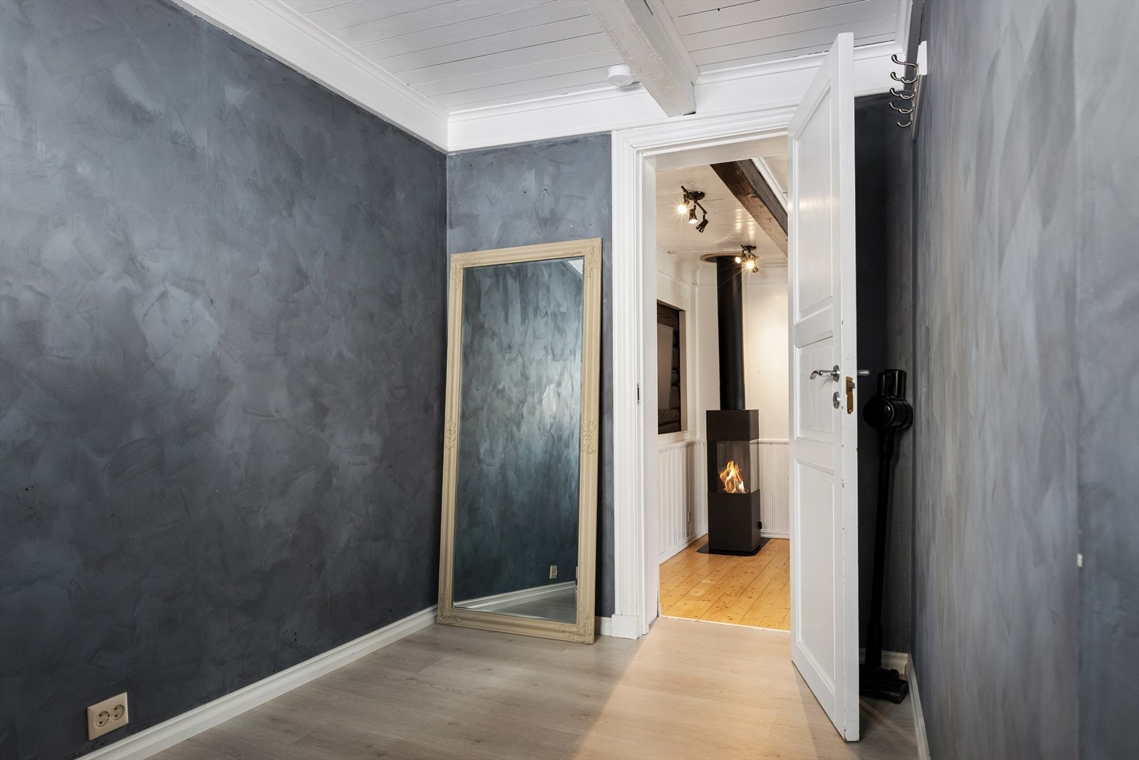 Lunt og innbydende soverom med behagelige fargetoner og synlige takbjelker som fremhever boligens karakter. Rommet har plass til seng og garderobeløsning. Galleribilde