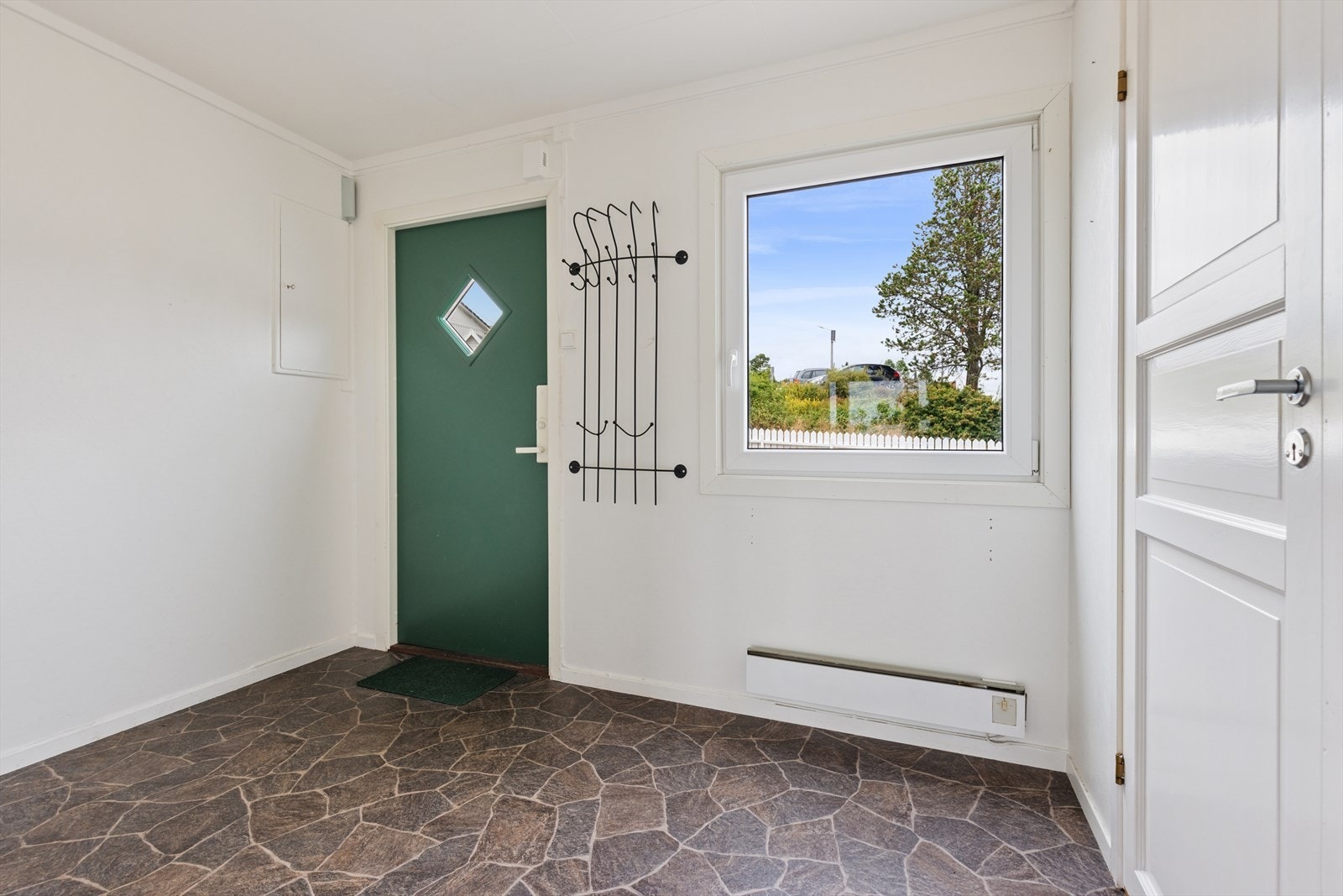 Velkommen inn i en romslig entré med god plass til oppbevaring av yttertøy og sko. Herfra er det også enkel adkomst til en praktisk innvendig bod. Galleribilde