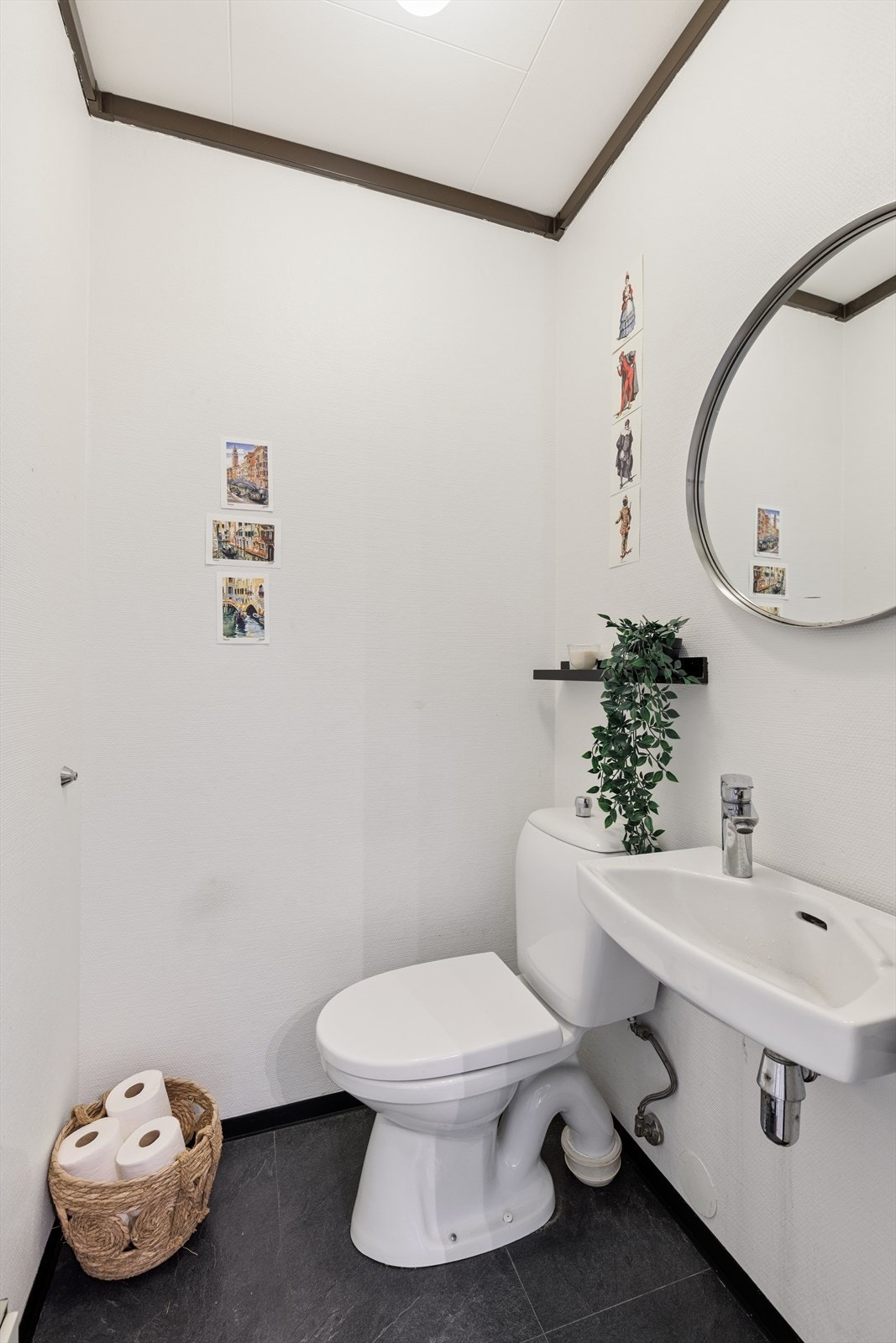 Separat toalettrom utstyrt med gulvstående toalett og vegghengt servant. Galleribilde