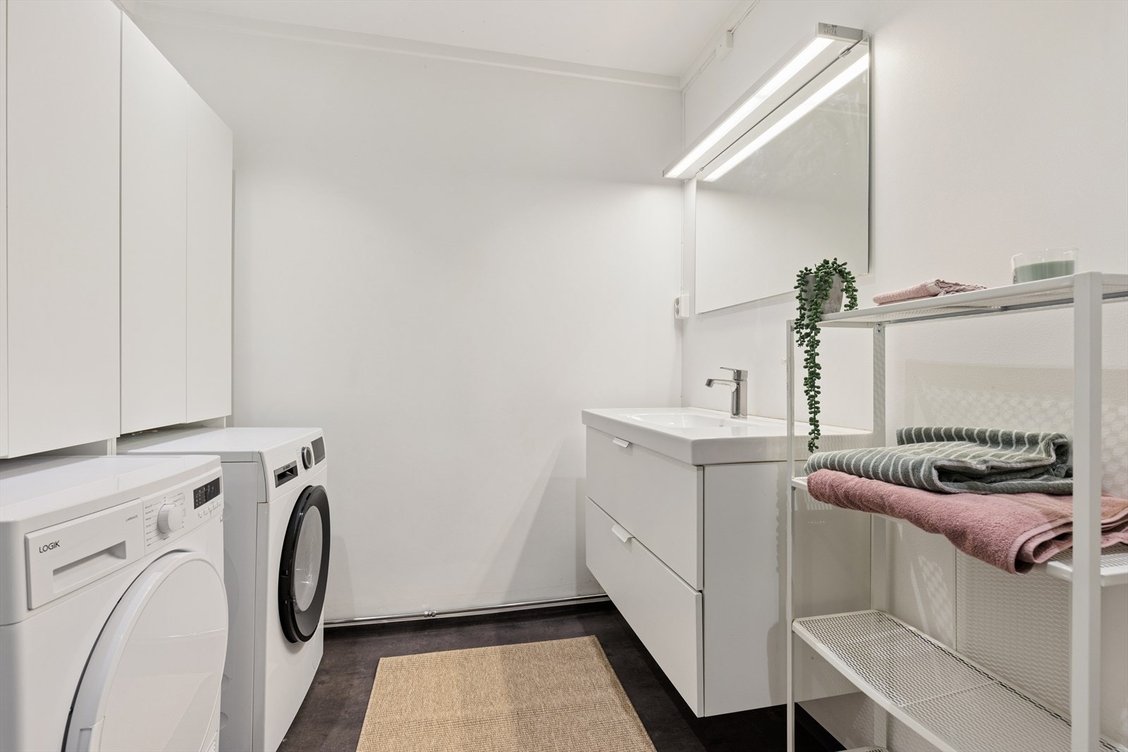 Badet har opplegg for vaskemaskin og plass til tørketrommel. Galleribilde
