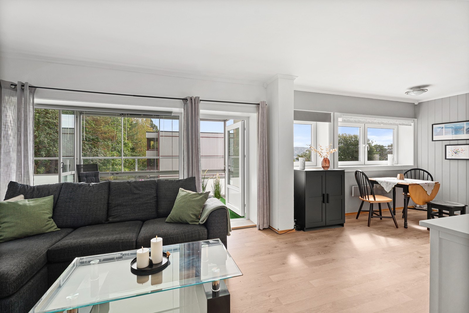 Stuen har god plass til både sofagruppe og spisegruppe, og ligger i delvis åpen løsning mot kjøkkenet. Store vindusflater og utgang til balkong bidrar til en lys og luftig atmosfære. Galleribilde