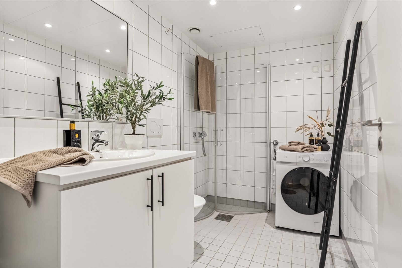 Flislagt bad med moderne overflater og opplegg for vaskemaskin. Galleribilde