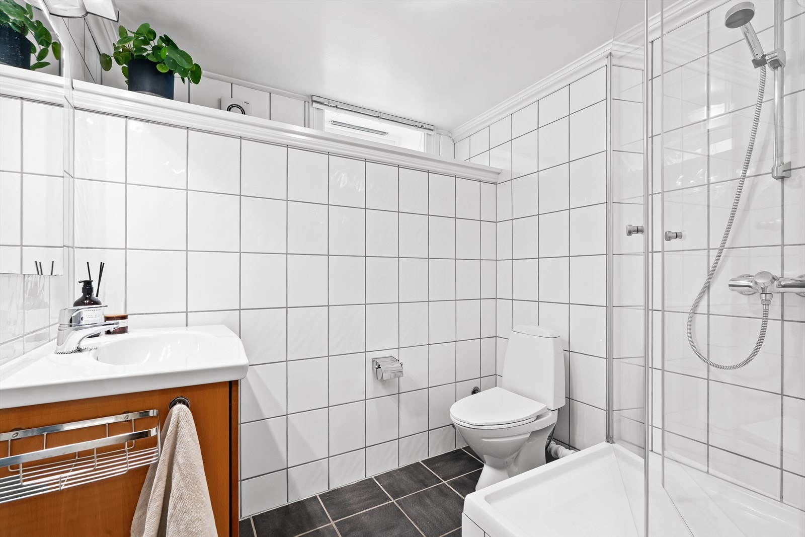 Badet har god størrelse og det er montert gulvstående toalett og dusjhjørne med herdet glass Galleribilde