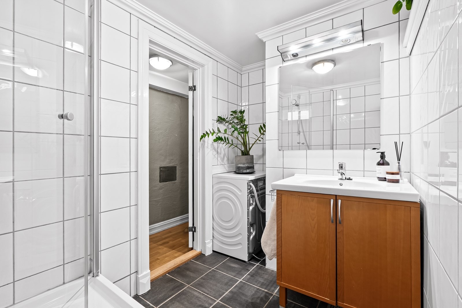 Stort og romslig flislagt bad fra 2003. Badet er innredet med en nedfelt servant og overhengende speil Galleribilde