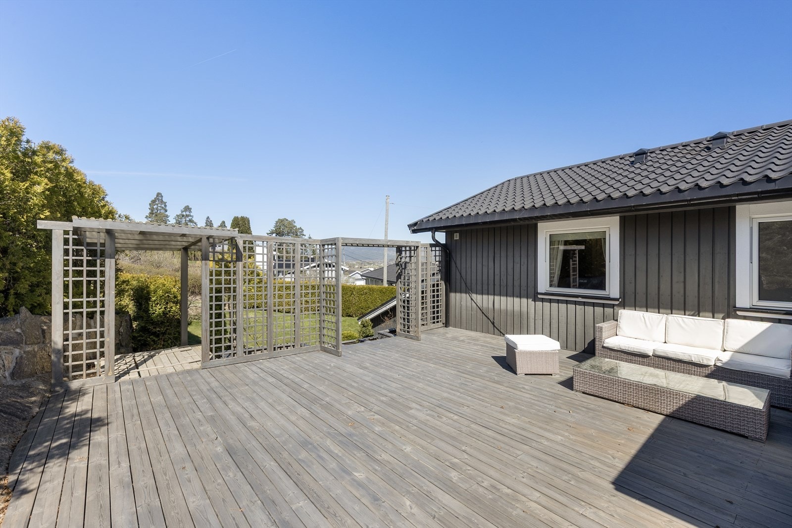 Uteområdet er pent opparbeidet med plen, beplantning og flere terrasserte nivåer. Galleribilde