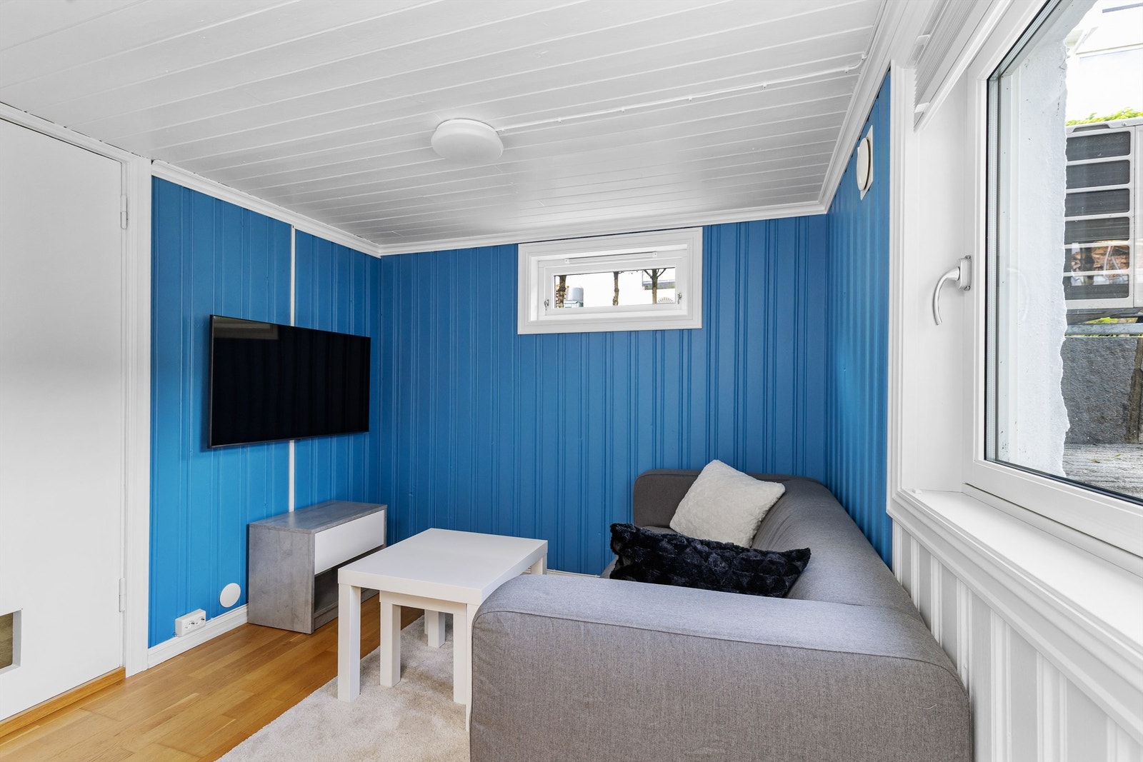 Rommet har panel på veggene og parkett på gulvet. Galleribilde