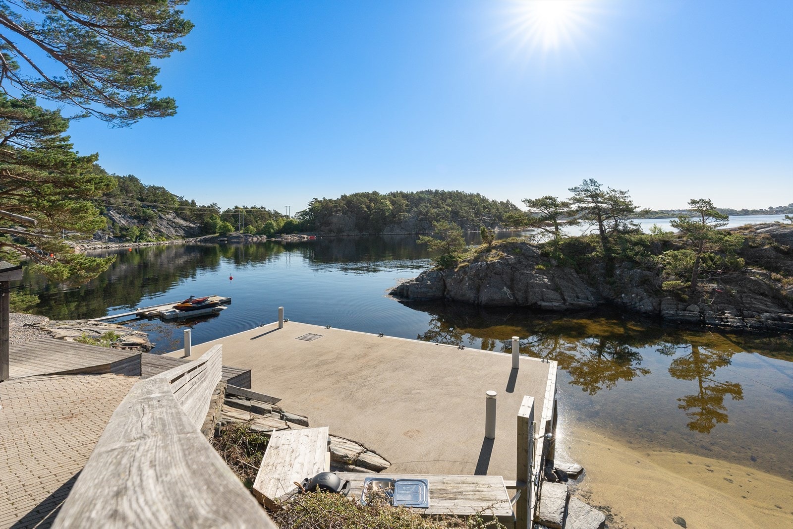 Bryggeanlegget er pent opparbeidet med betongbrygge, utvendig belysning, utekjøkken, samt utedusj. Galleribilde