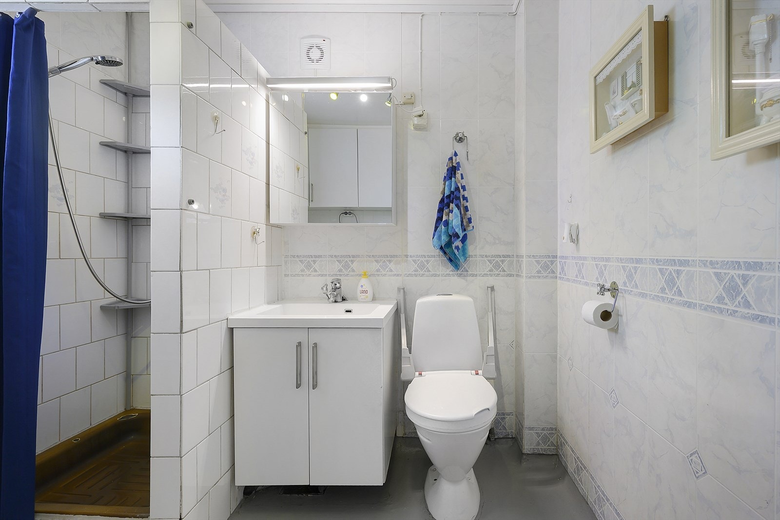Badet i første etasje har fliser på veggene rundt dusjen og vinylbelegg på gulvet. Galleribilde