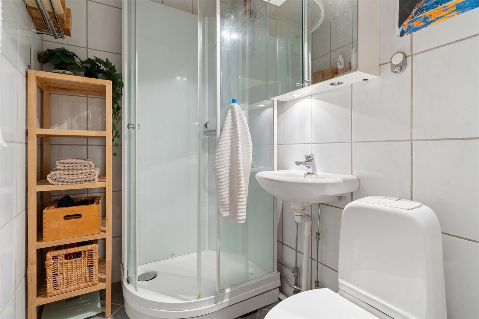Badet er utstyrt med speilskap med integrert belysning og stikkontakt. Galleribilde