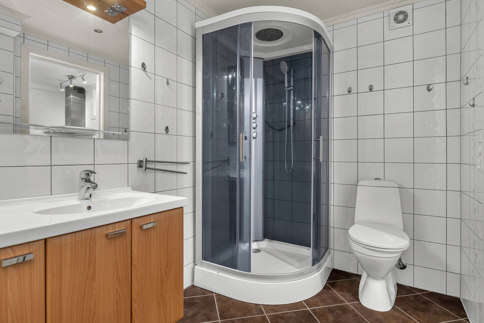 Badet er innredet med dusjkabinett og toalett. Galleribilde