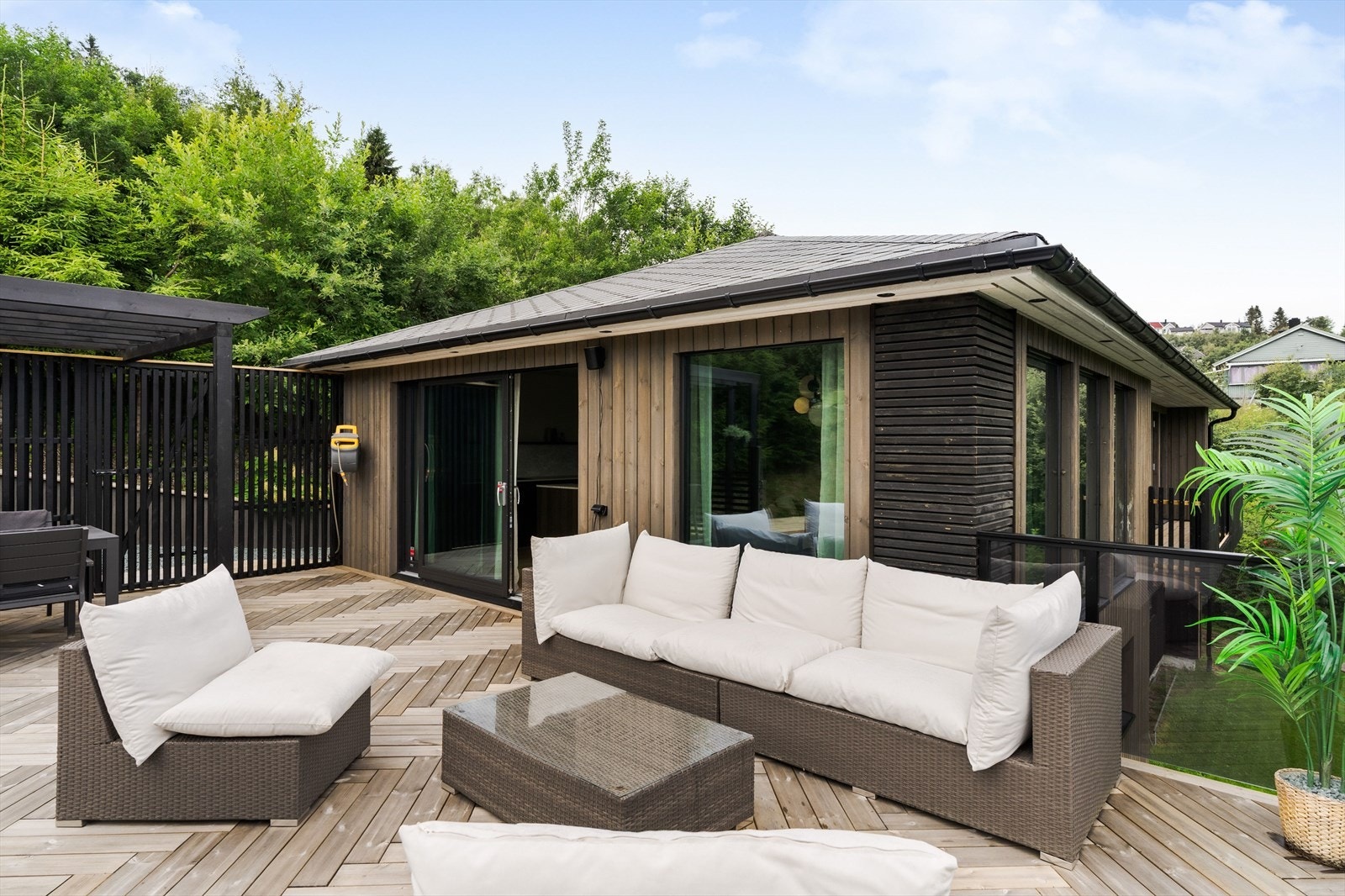 Glassrekkverket ivaretar utsikten og understreker boligens moderne uttrykk. Det er også opparbeidet en stor, åpen terrasse på et lavere nivå samt plenarealer rundt boligen. Galleribilde