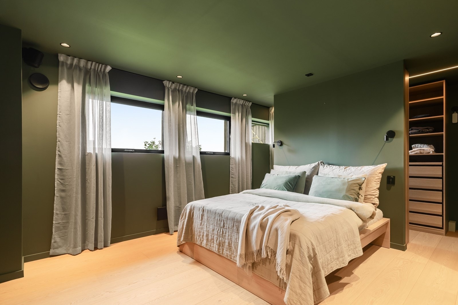 Hovedsoverommet i sokkeletasjen er på ca. 20 m² og fremstår som en privat og innbydende avdeling. Rommet har en lun grønnfarge, flere vinduer og god plass til dobbeltseng. Galleribilde