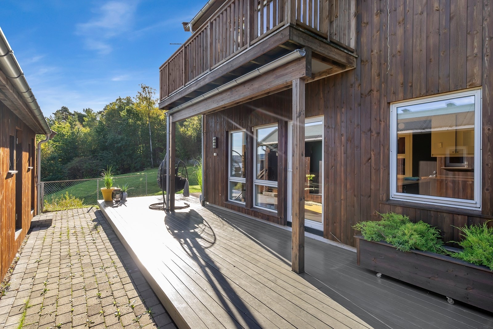 Stor terrasse/platting med plass til flere sittegrupper og grill Galleribilde
