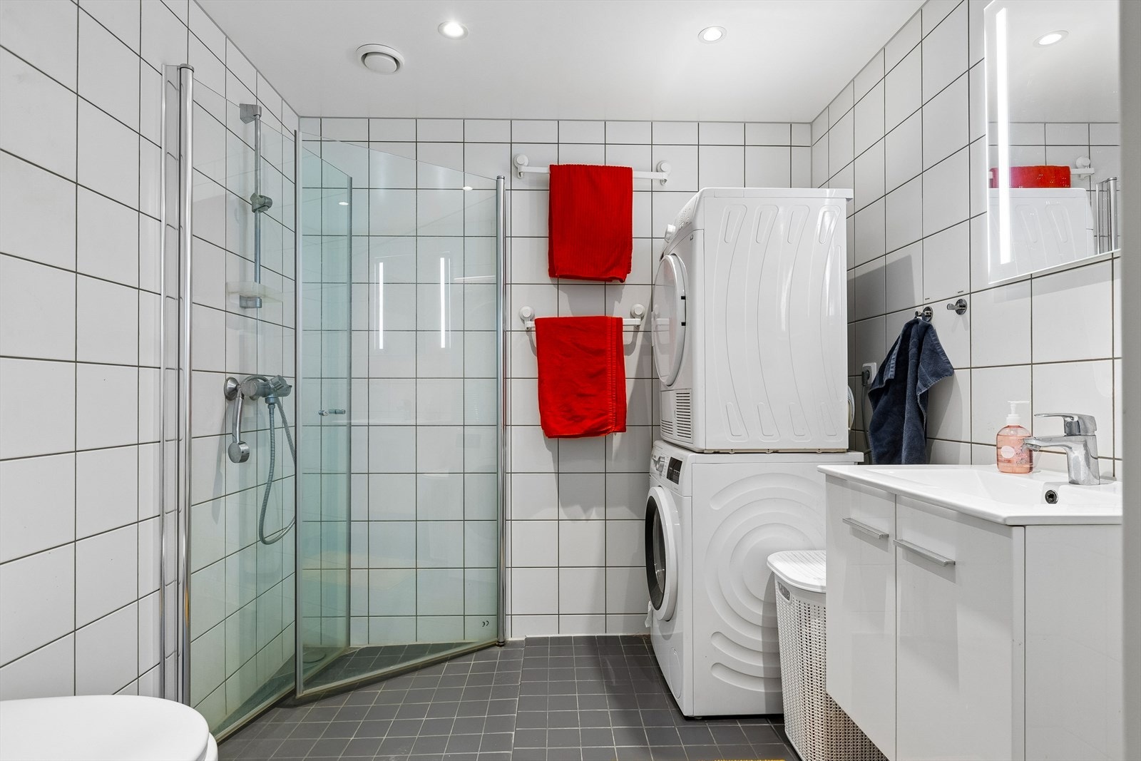 Det 4,6 m² delikate badet fremstår som innbydende med helflisede overflater, behagelig gulvvarme og downlights i tak. Galleribilde