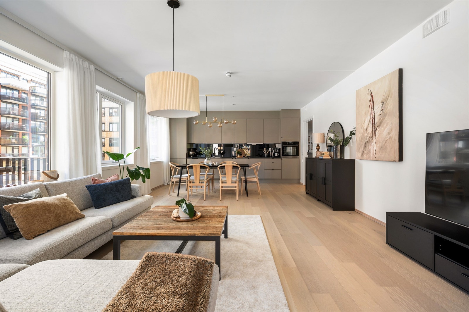 Stor og luftig stue med mange vindusflater på to sider som slipper inn lys Galleribilde