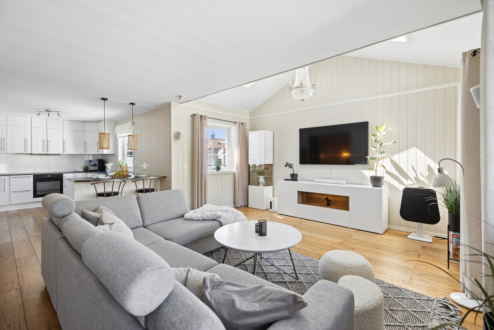 En sosial og luftig løsning hvor kjøkken og stue ligger i naturlig tilknytning til hverandre. Den gode takhøyden og de mange vindusflatene bidrar til en lys og behagelig atmosfære. Galleribilde