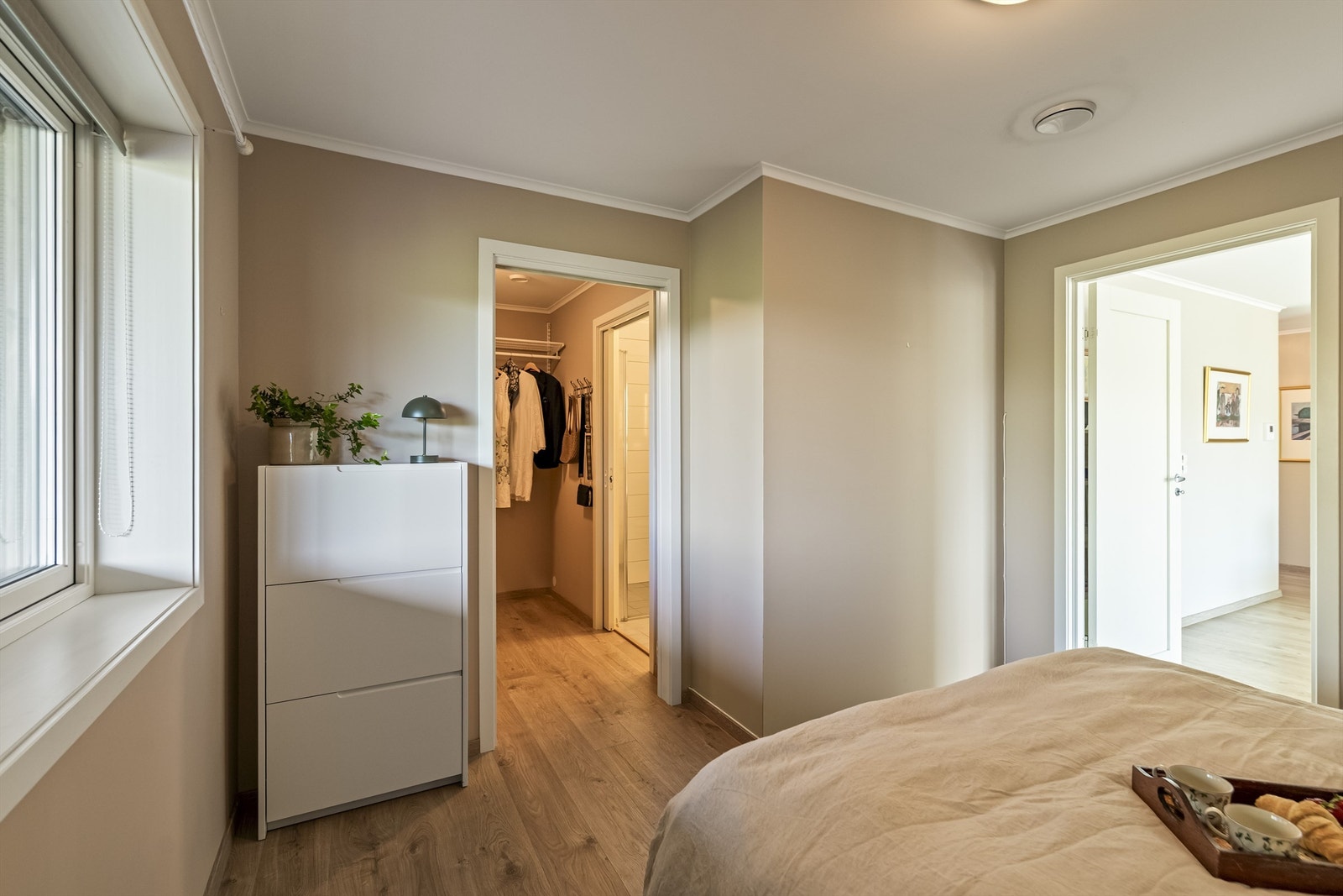 Hovedsoverommet fremstår som romslig og innbydende, med direkte tilknytning til både praktisk walk-in-garderobe og eget bad. Galleribilde