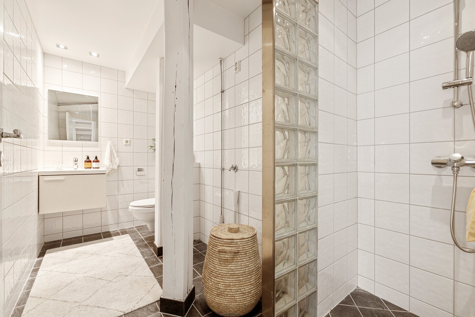Badet har flislagte gulv og vegger i lyse toner, samt malt himling med downlights som gir et rent og moderne uttrykk. Galleribilde