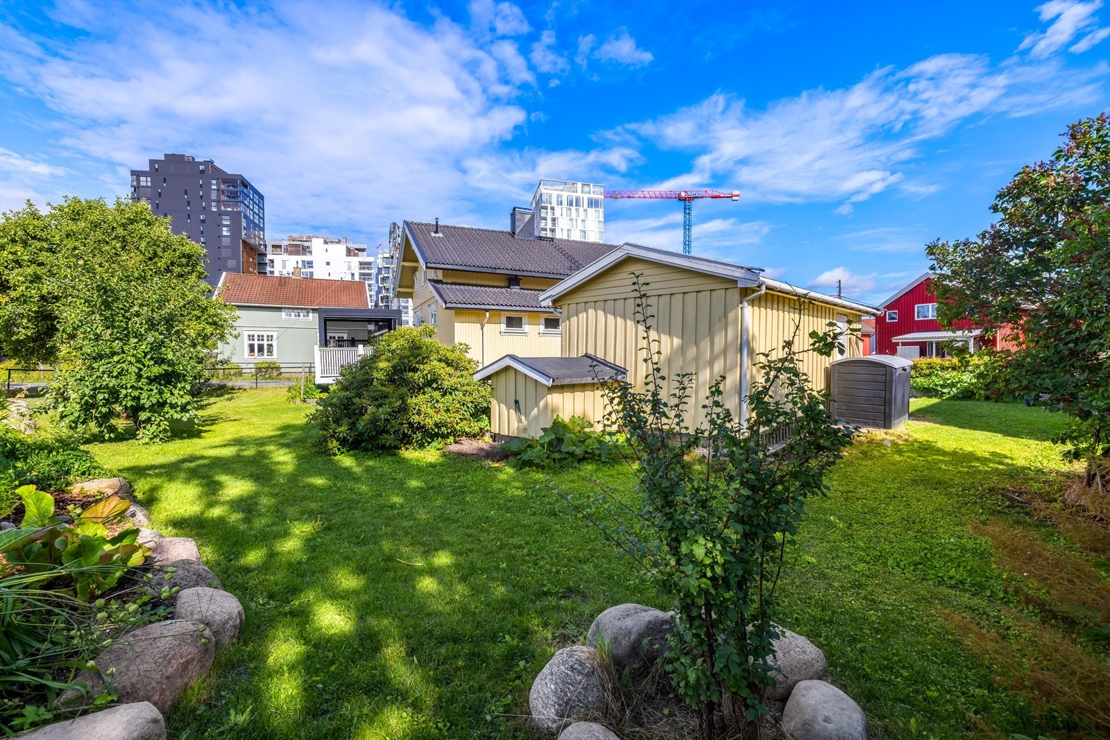 Eiendommen har en pent opparbeidet og lettstelt tomt med store plenarealer, frodige beplantninger, blomsterbed og prydbusker som skaper et grønt og innbydende utemiljø. Galleribilde
