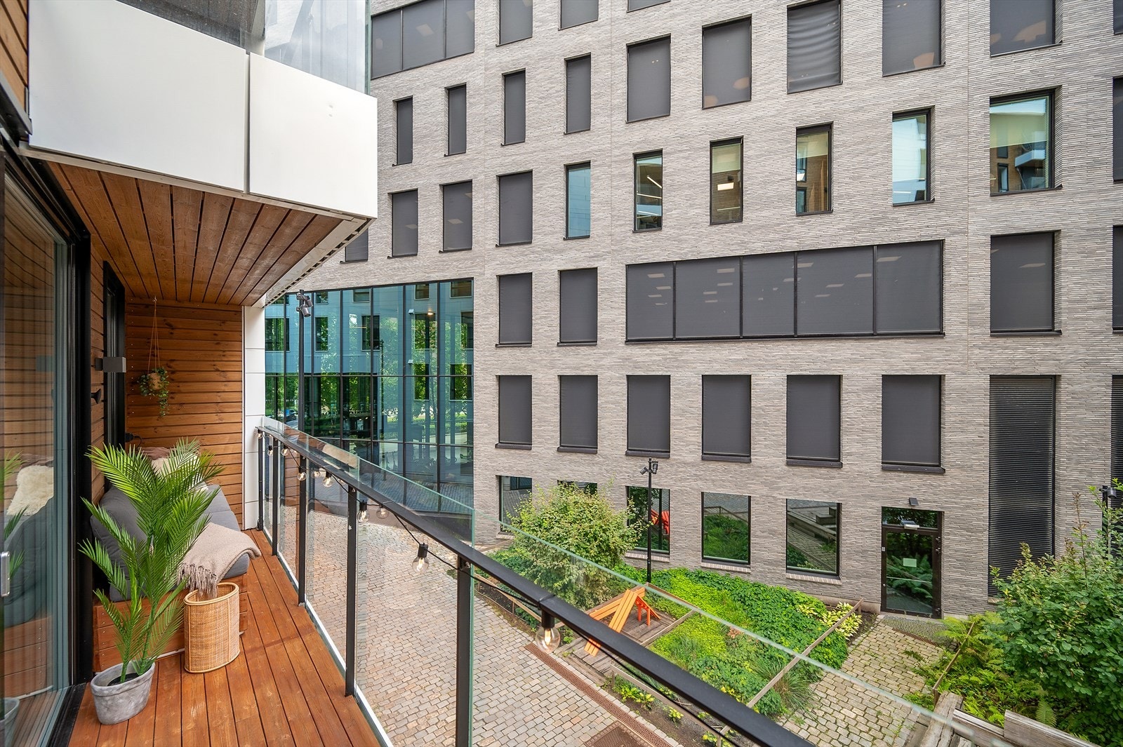 Balkongen er delvis overbygget, og har glassrekkverk samt gulv belagt med terrassebord Galleribilde