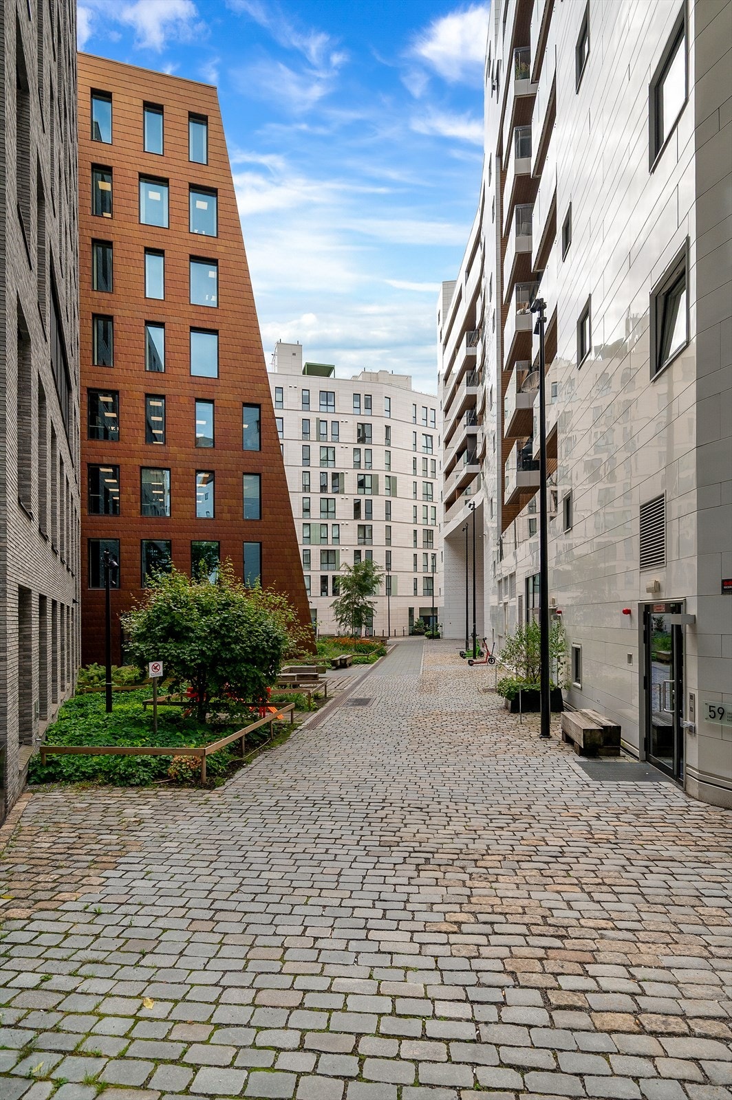 Sameiets fellesarealer er pent opparbeidet med brostein, beplantning, prydbusker og hyggelige sittegrupper Galleribilde