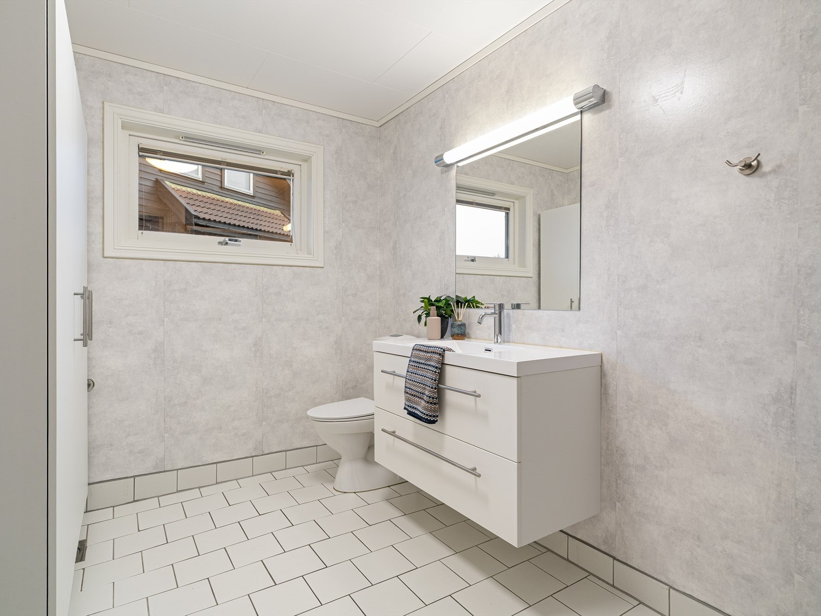 Badet er innredet med servantmøbel og toalett. Galleribilde
