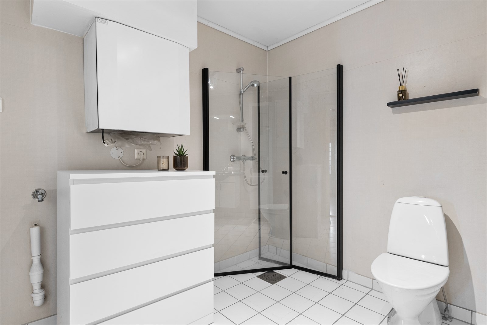 Badet er utstyrt med dusj, toalett, servant med innredning og opplegg for vaskemaskin Galleribilde