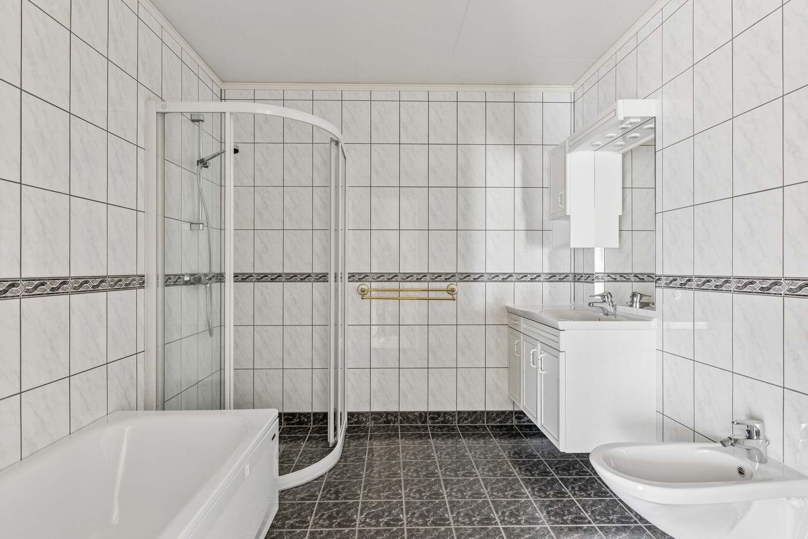 Badet i kjelleren har flislagte vegger og flislagt gulv med vannbåren varme. Galleribilde