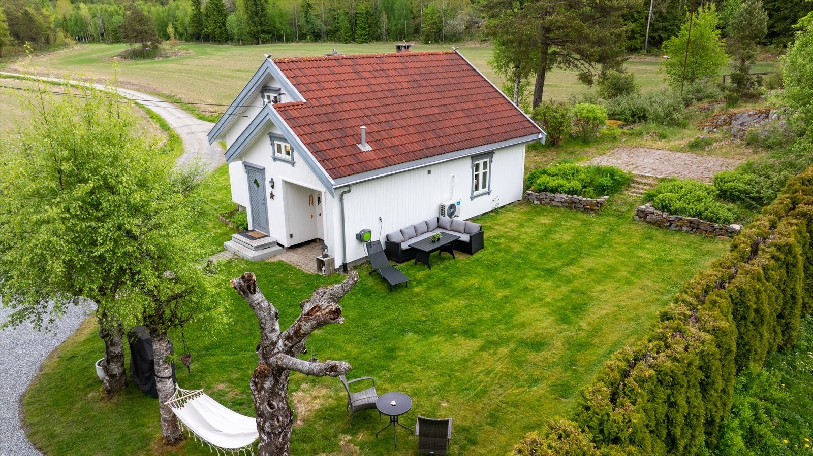 Tunet består blant annet av en koselig enebolig med grønn og pen hage. Galleribilde