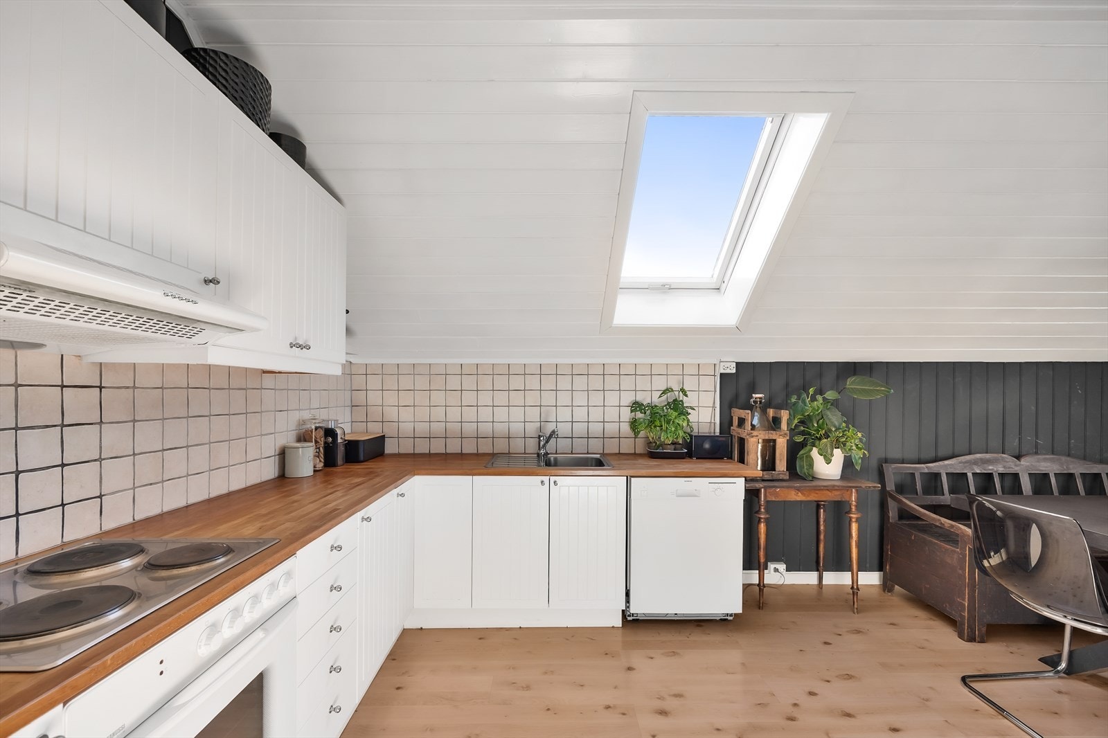 Kjøkkenet er vinkeltformet og har hvite, profilerte fronter. Galleribilde