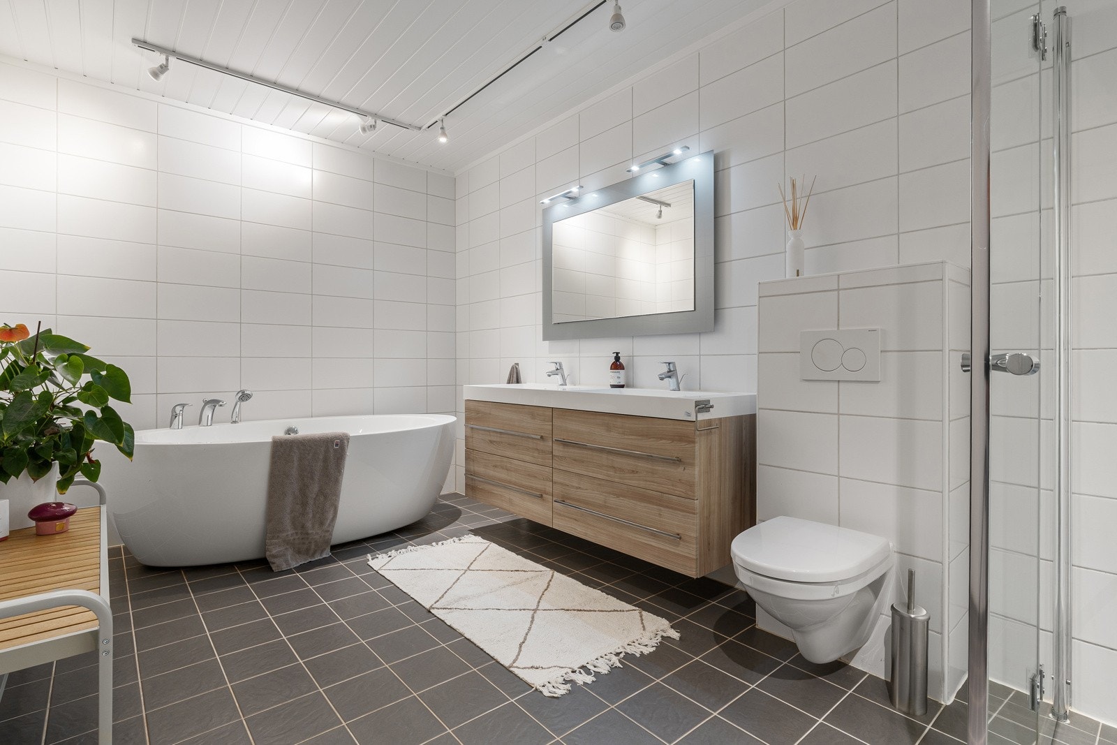 Innbydende baderom med både dusj, badekar, servant og toalett. Badet ligger i 1.etg.