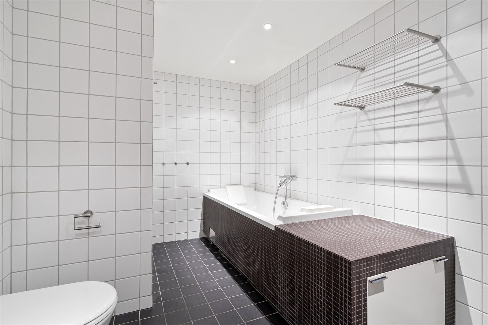 Både dusjhjørne og badekar i familiebadet Galleribilde