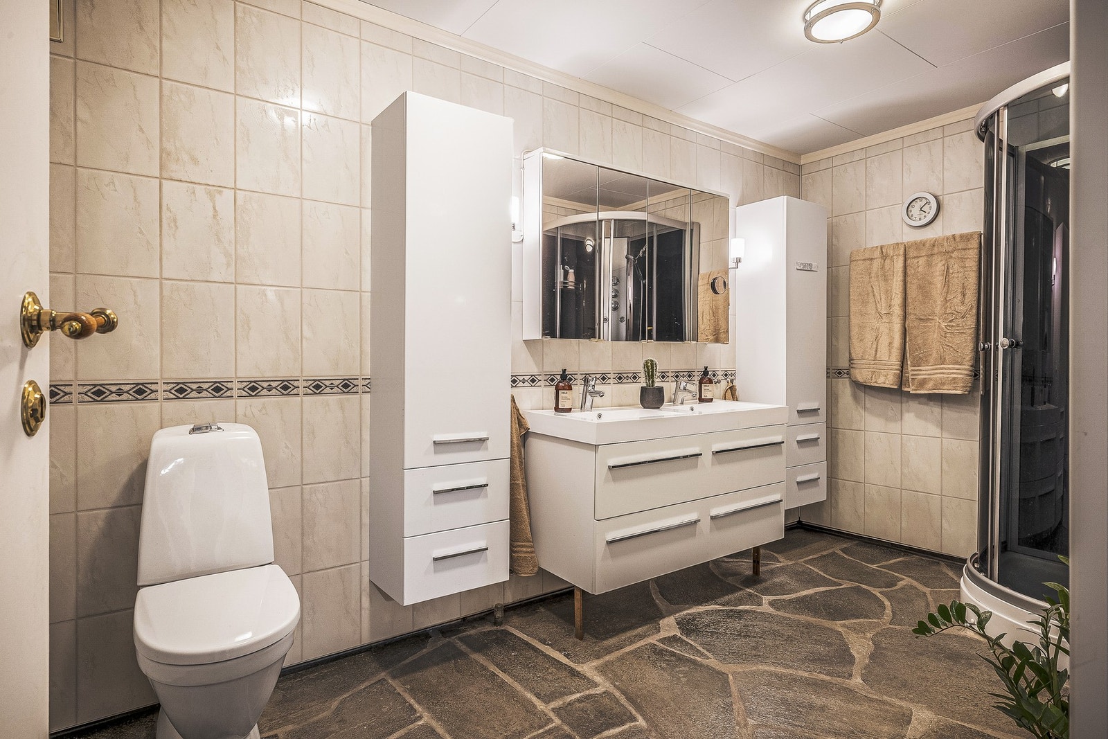 Badet har skifergulv med varmekabler, vegger kledd med baderomsplater og malte himlingsplater i taket. Galleribilde