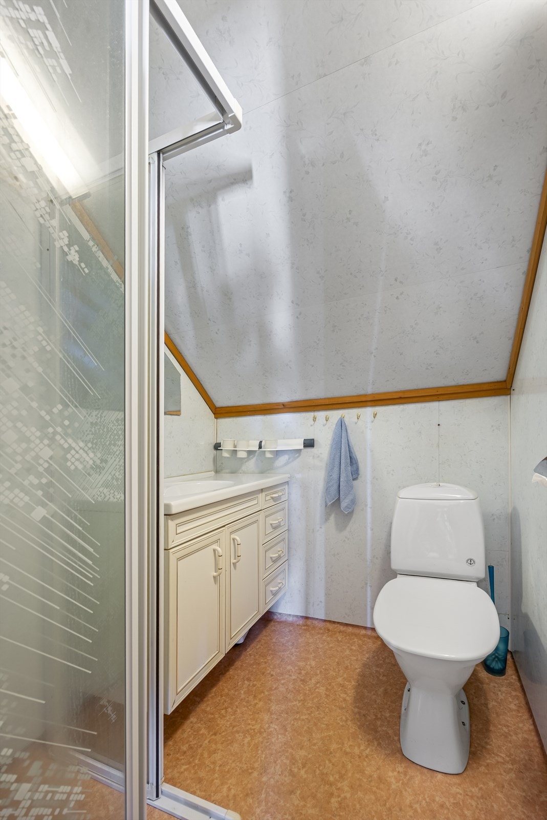 Badet på loftet har dusjnisje, gulvstående toalett og baderomsplater på veggene. Galleribilde