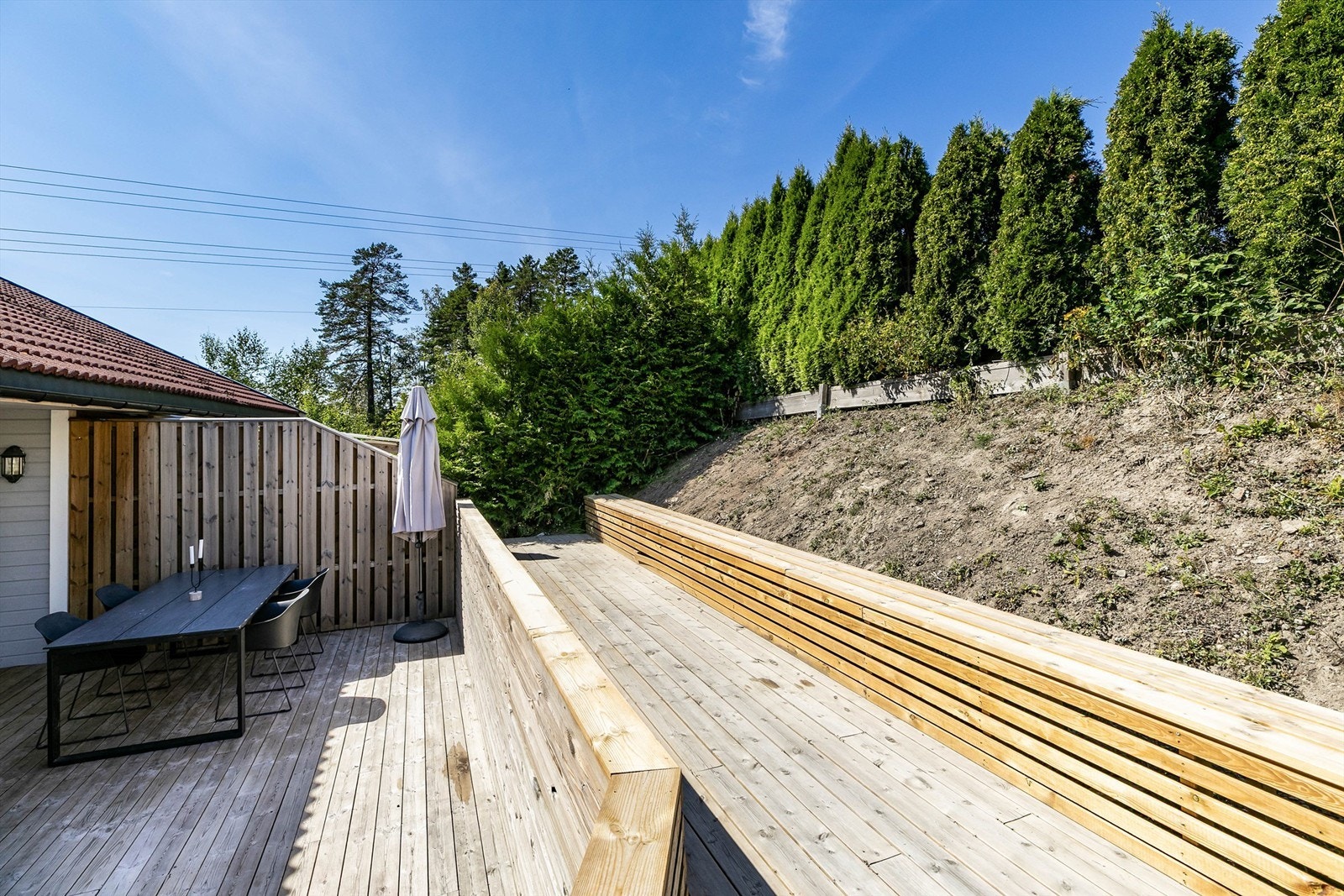 Et høyere nivå over terrassen er anlagt helt nylig, med langstrakt sittebenk. Beplantning kan gi nytt liv til den solfylte skrenten ovenfor. Galleribilde