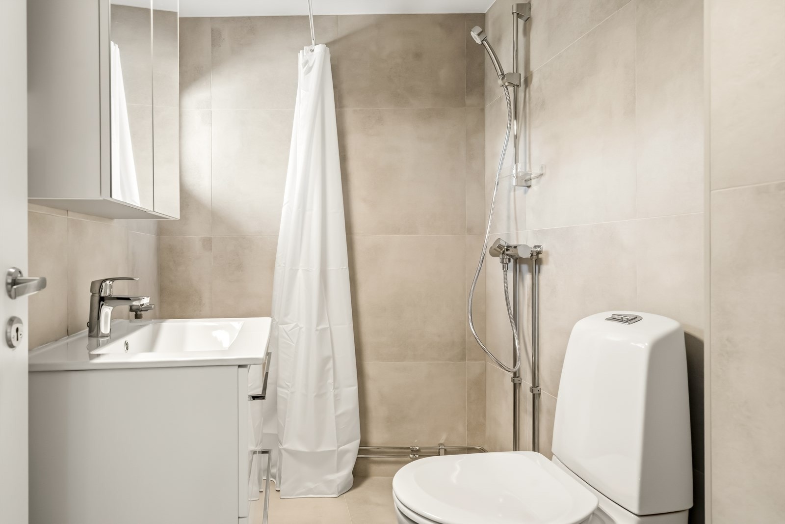 Badet ble oppgradert i 2026 med flislagte overflater og elektrisk gulvvarme. Galleribilde