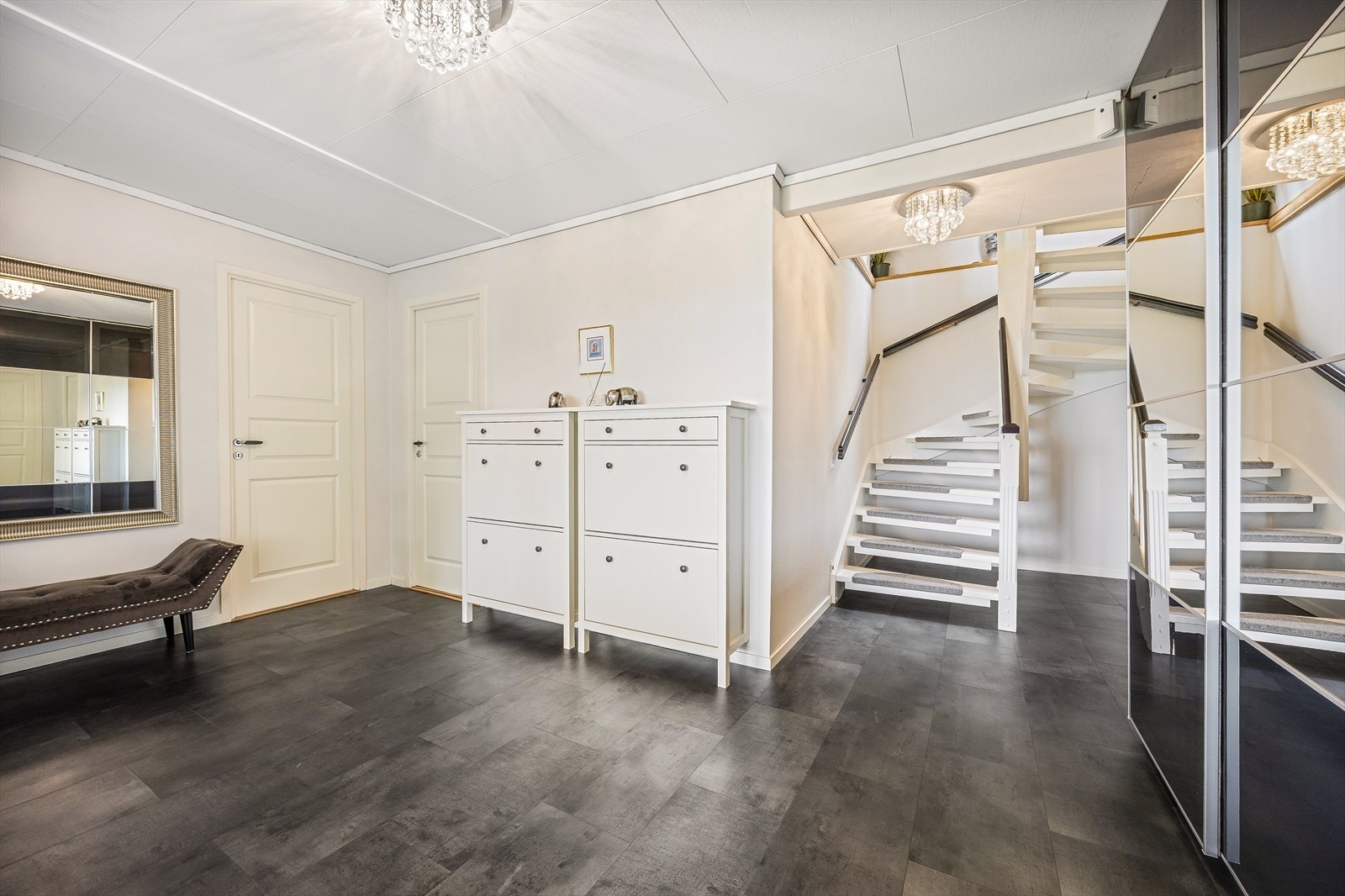 Fra inngangspartiet kommer man inn i en romslig gang som leder videre til et kontor, vaskerom og boder. Her er varmekabler i gulv. Galleribilde