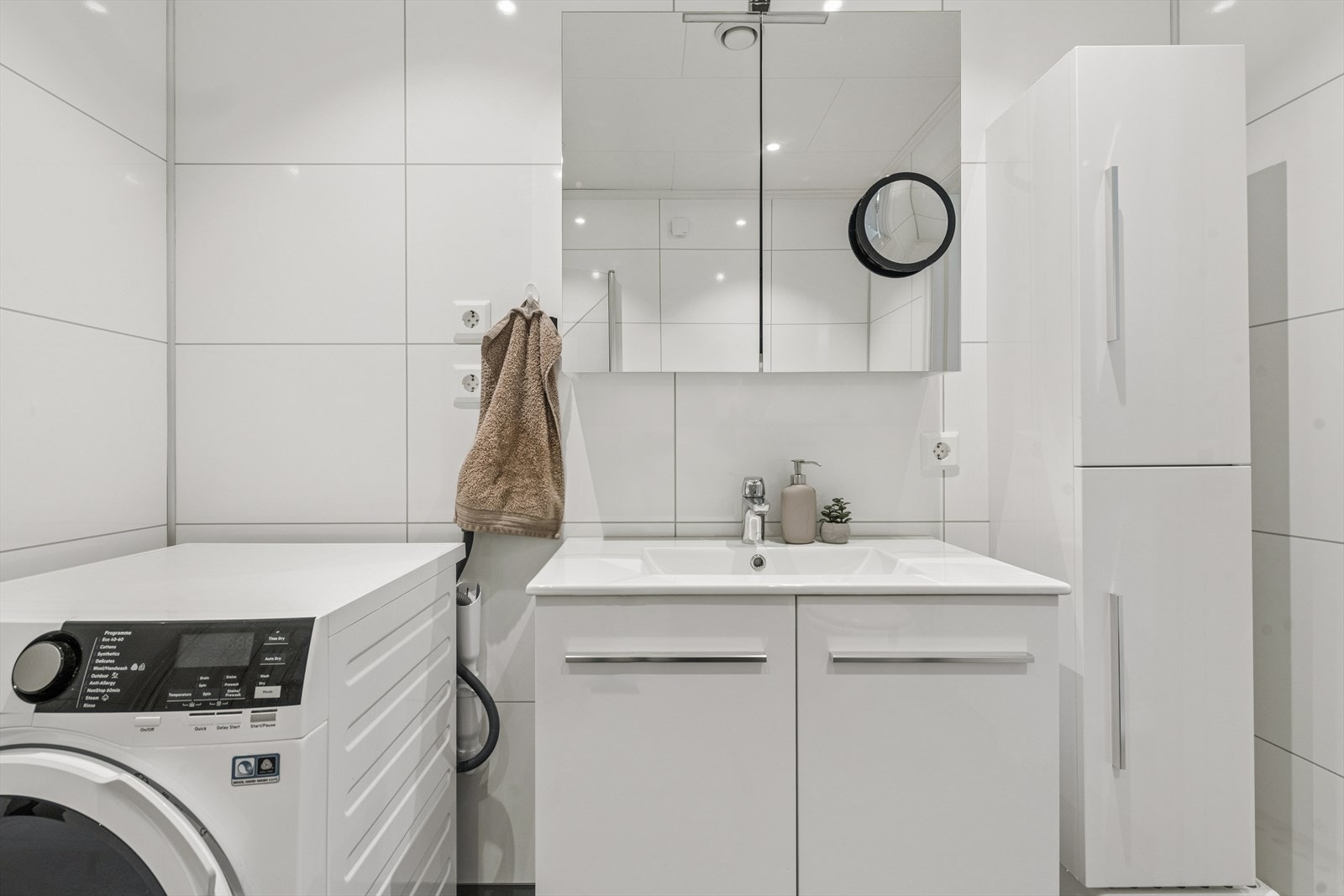 Badet er innredet med servantmøblement, høyskap, toalett og dusjhjørne. Galleribilde