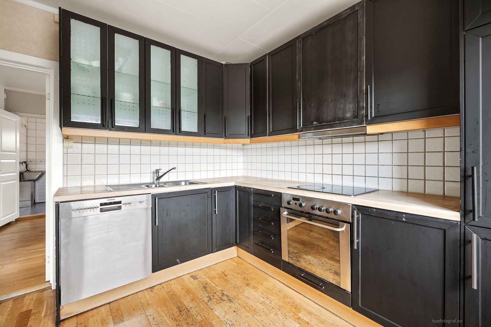 Kjøkkeninnredning med profilerte fronter og benkeplate i heltre. Rommet er utstyrt med platetopp, stekeovn og oppvaskmaskin. Galleribilde
