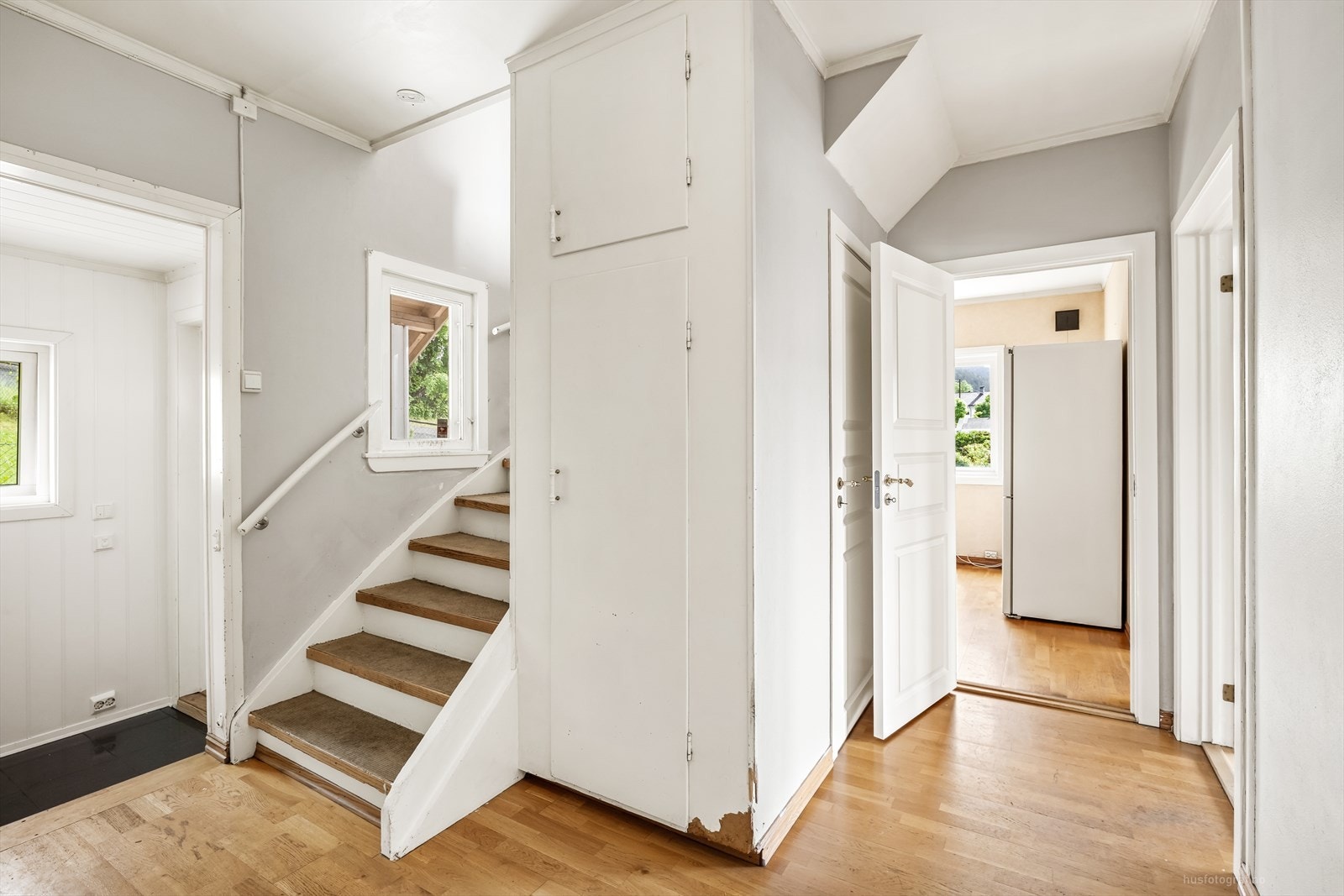 Entréen har plass til oppbevaring og leder videre inn til boligens oppholdsrom og trapp til andre etasje. Galleribilde