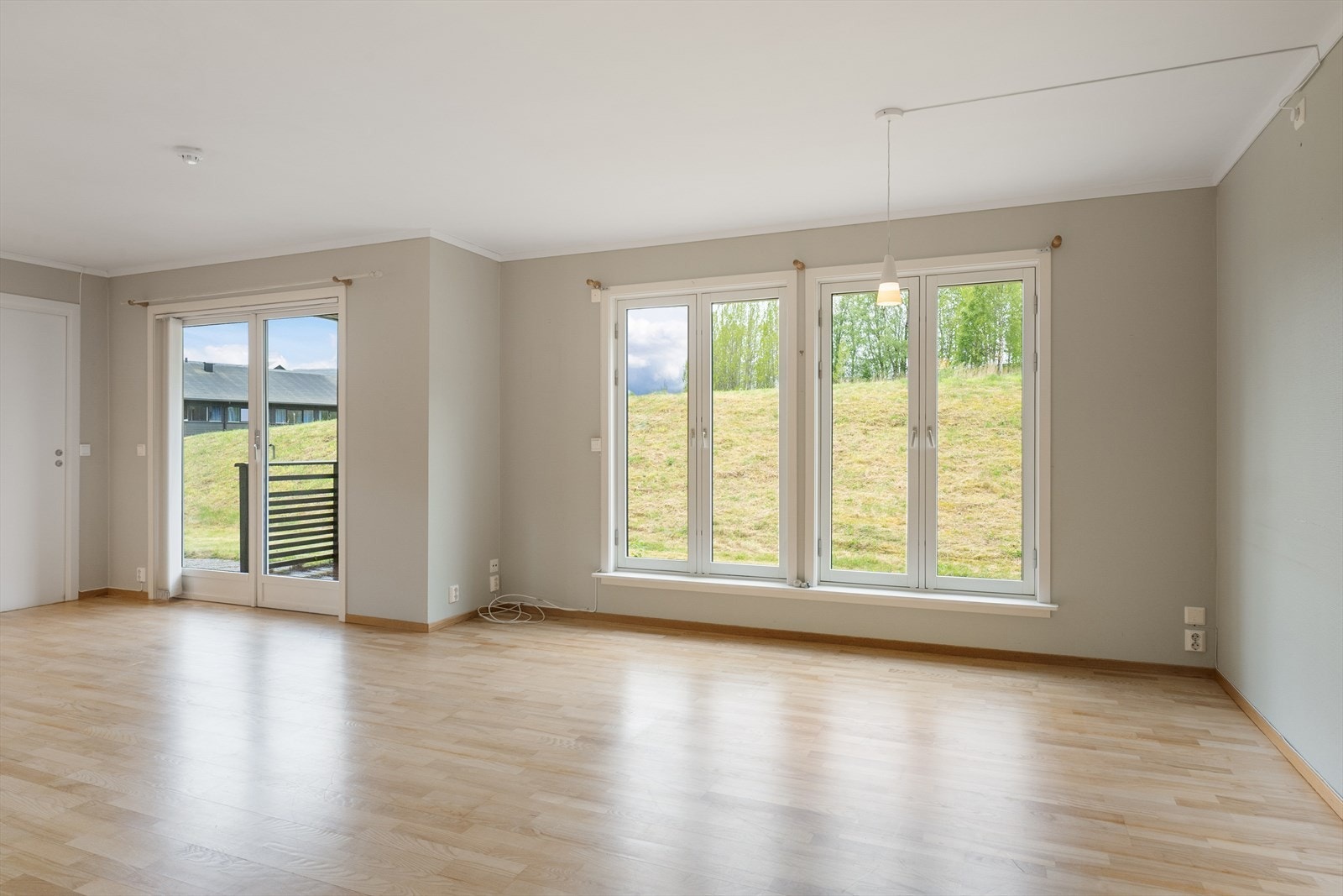 Store vindusflater gir rikelig med naturlig lys inn i stuen. Galleribilde