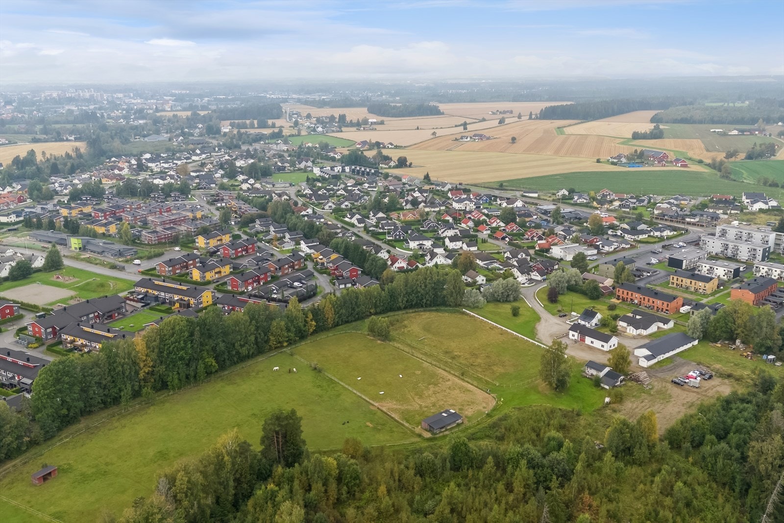 Stor gårdsplass med flere bygninger, ridebane, paddocker m.m. Galleribilde