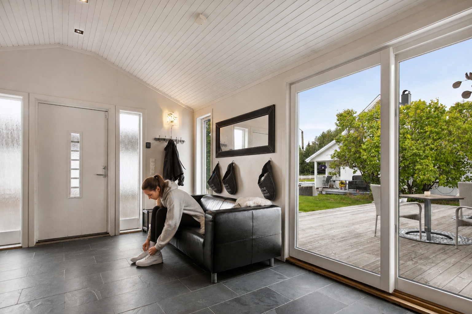 Velkommen inn... Pent flislagt gulv med gulvvarme og god takhøyde. Skyvedører ut mot hage og terrasse. Galleribilde
