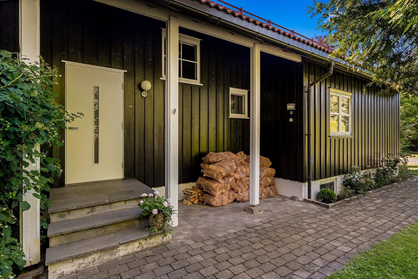 Overbygget inngangsparti med plass til vedstabel og sittebenk. Galleribilde